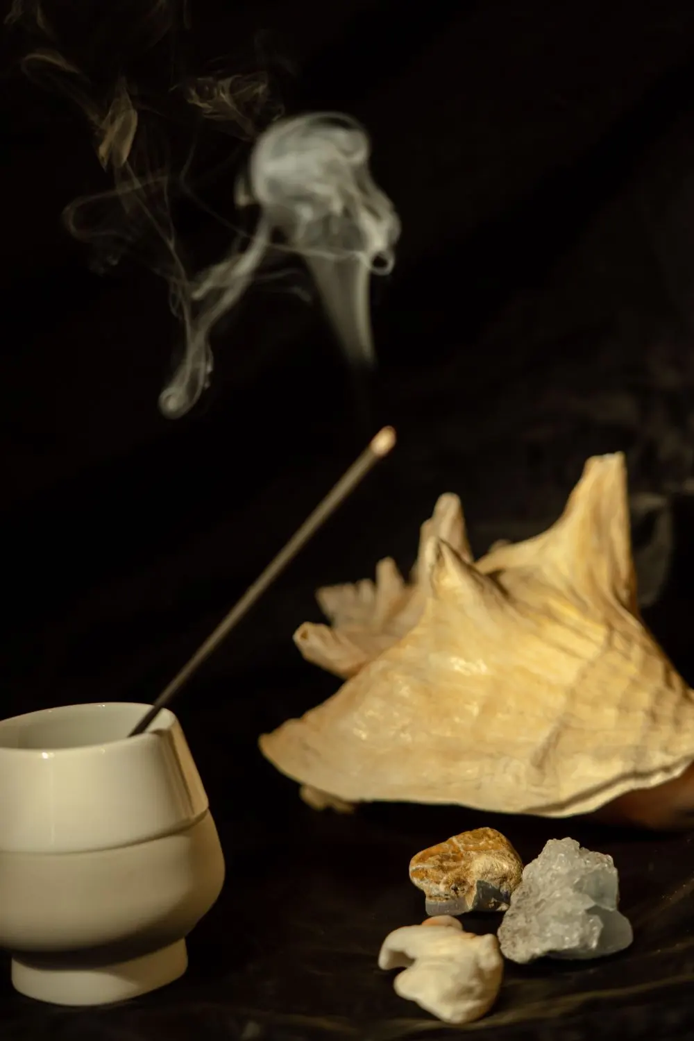 Bâton d'encens fumant et coquillages, rituel de protection